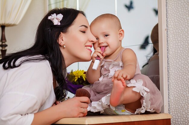 Hija ayudando a la madre a usar el pincel para el maquillaje