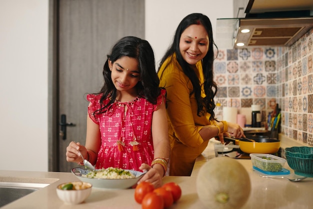 La hija ayudando a su madre en la cocina