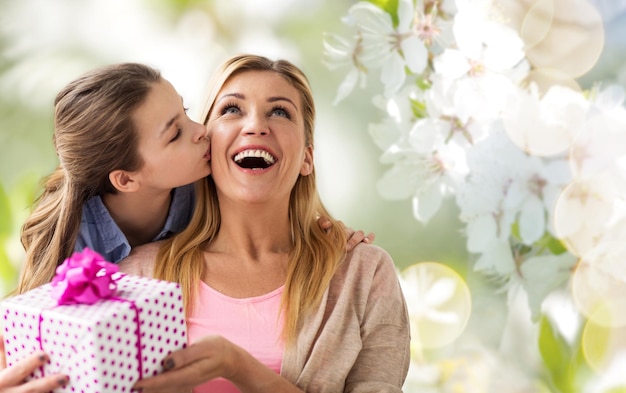 Foto hija besando a su madre y dándole un regalo