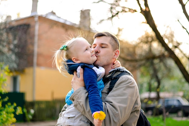 Hija en brazos del padre Papá con niño papá besa a hija