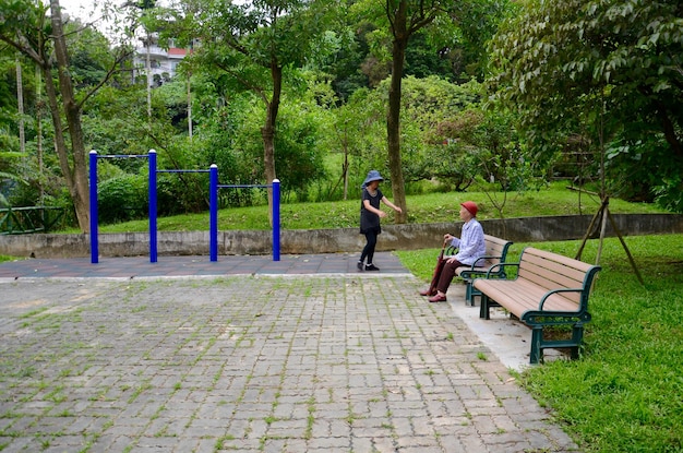 Foto la hija caminando hacia la madre sentada en un banco en el parque