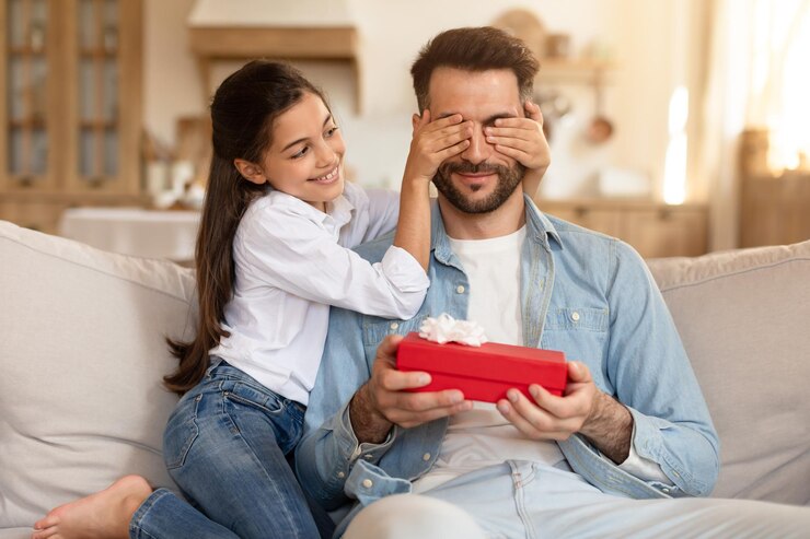 Foto la hija cubriendo los ojos del padre regalo en su mano