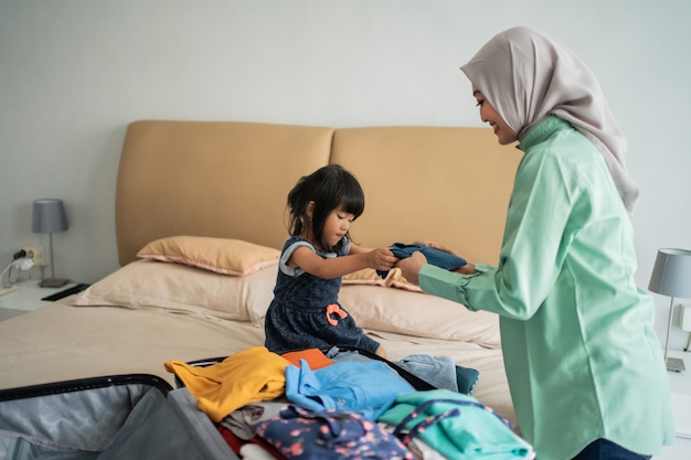 Hija le da ropa a su madre para preparar la maleta