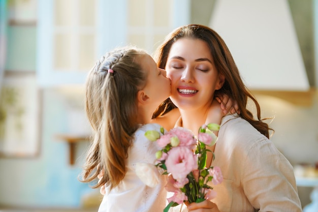 Hija dando a madre ramo de flores