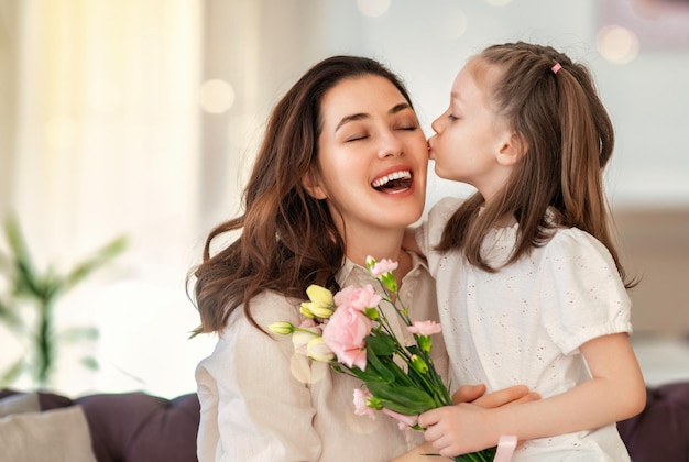 Hija dando a madre ramo de flores