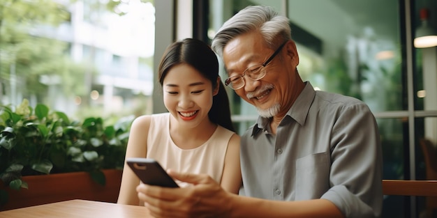 Hija enseñando a un anciano asiático o a un padre usando tecnología de Internet en las redes sociales con un dispositivo digital en casa