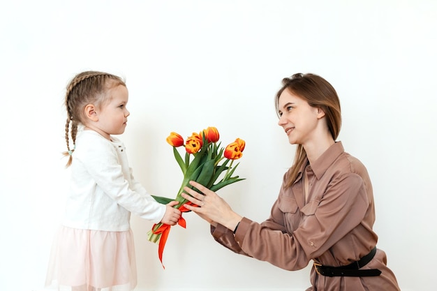 Hija feliz felicita a mamá con tulipanes