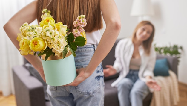 Hija con flores en caja para madre.