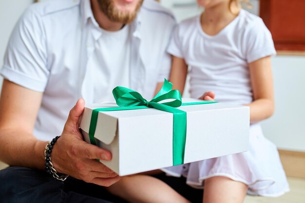 Hija irreconocible felicitando a papá y dando regalos de cumpleaños en casa