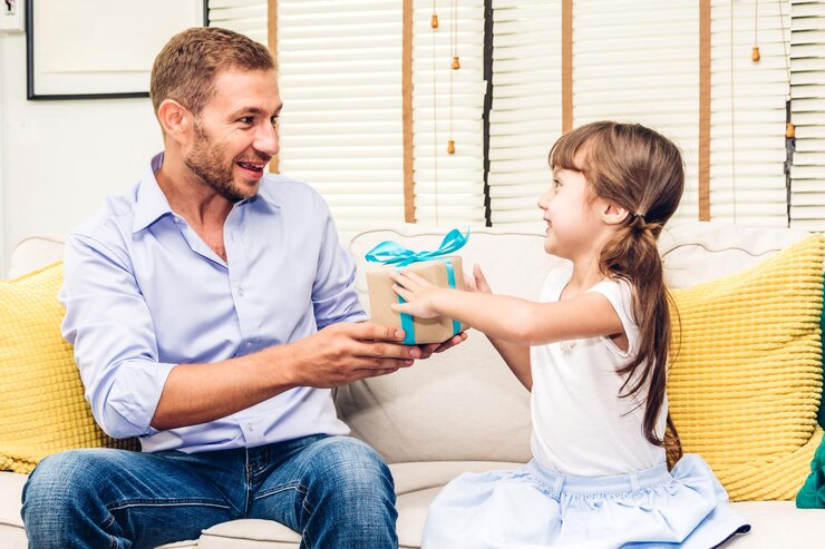 Foto la hija linda le da una caja de regalos a su padre en casa.