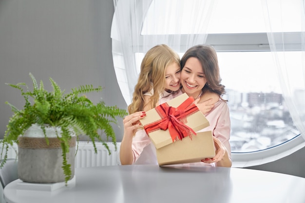 Foto hija y madre abrazándose y sonriendo.