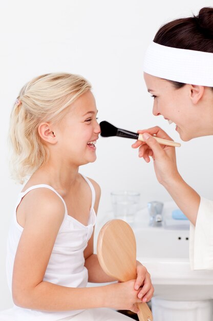 Hija y madre poniendo maquillaje