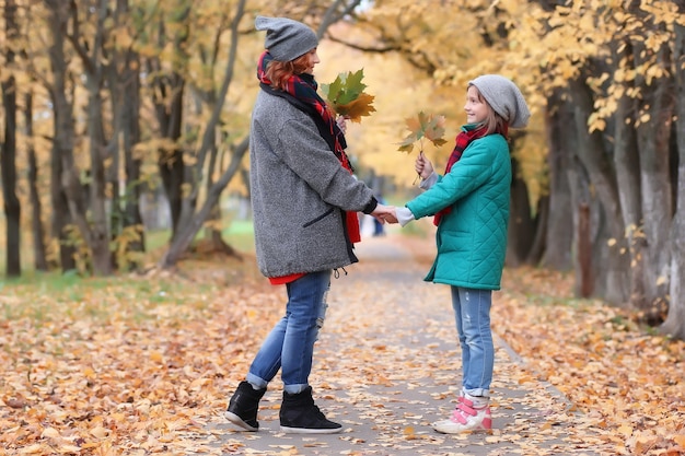 Hija y mujer de familia caminan parque otoño