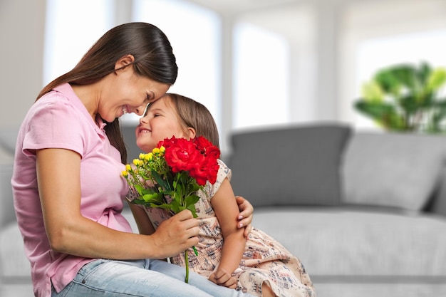 Foto la hija del niño felicita a mamá y le da flores.