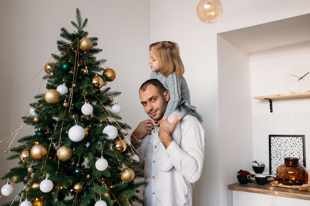 Hija y padre en casa cerca del árbol de Navidad en Navidad en casa