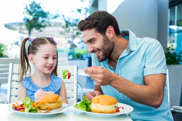 Hija y padre comiendo en el restaurante