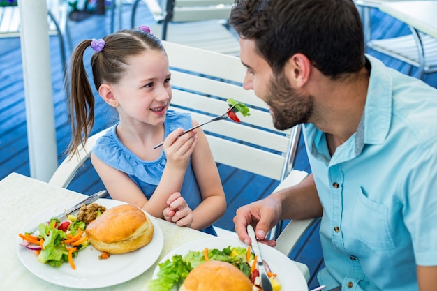 Hija y padre comiendo en el restaurante