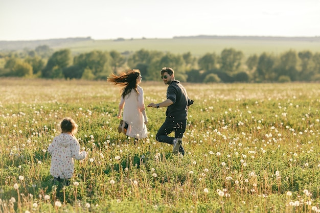 Hija de padre, madre e hijo de familia feliz en la naturaleza al atardecer