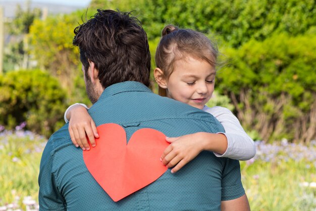 Hija que le da a papá una tarjeta de corazón