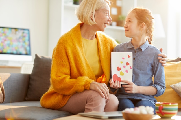 Hija que da la tarjeta de San Valentín a mamá