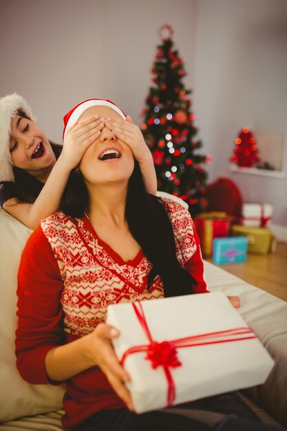 Hija sorprendiendo a su madre con regalo de navidad.