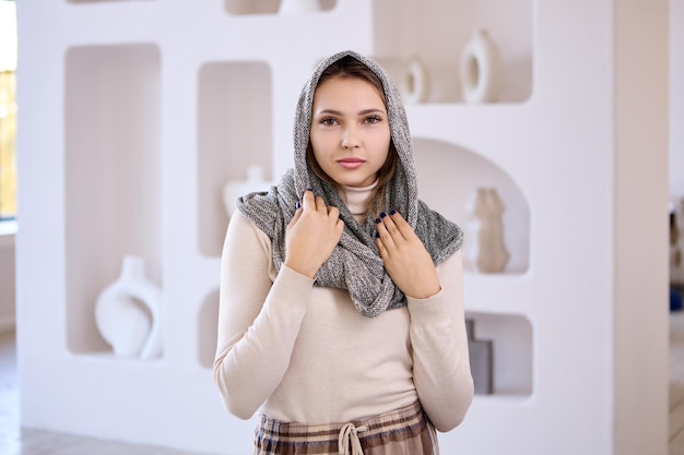 Hijab en la cabeza de una mujer de pie en el interior del salón