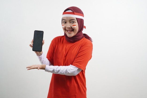 Foto hijab mujer día de la independencia de indonesia con teléfono señalador