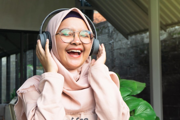 Hijab mujer escucha música a través de auriculares