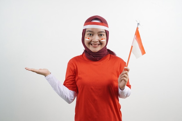 Foto hijab mujer sosteniendo bandera roja y blanca y mostrando algo
