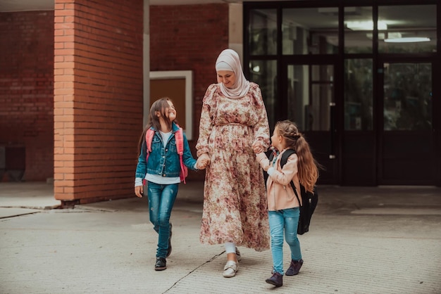 Hijab muslimische Mutter, die ihre Kinder zur Schule führt Selektiver Fokus Hochwertiges Foto