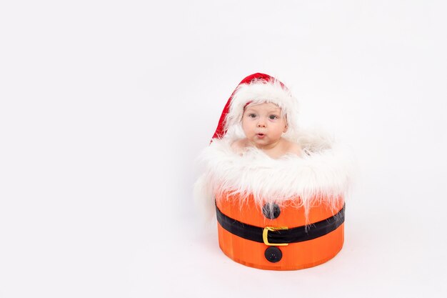 Hijita con gorro de Papá Noel sentado en una canasta