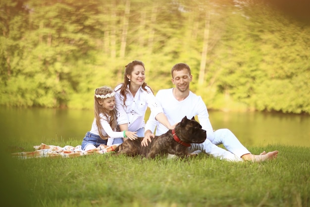 , hijita y su perro en un picnic junto al río.La foto tiene un espacio para tu texto.