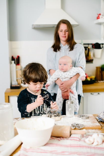 Hijo ayuda a madre a cocinar en la cocina