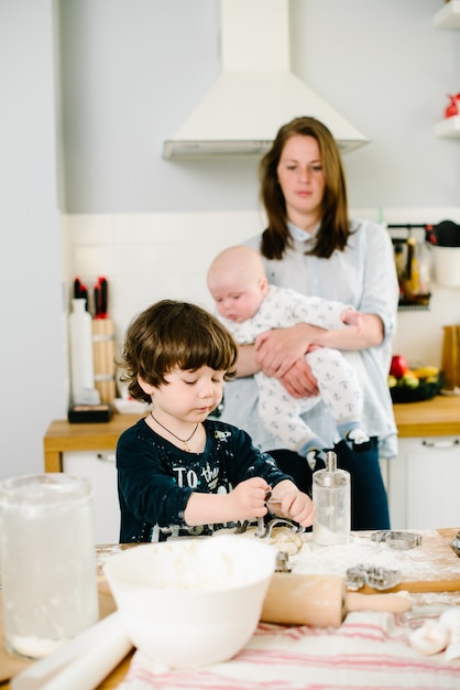 Hijo ayuda a madre a cocinar en la cocina