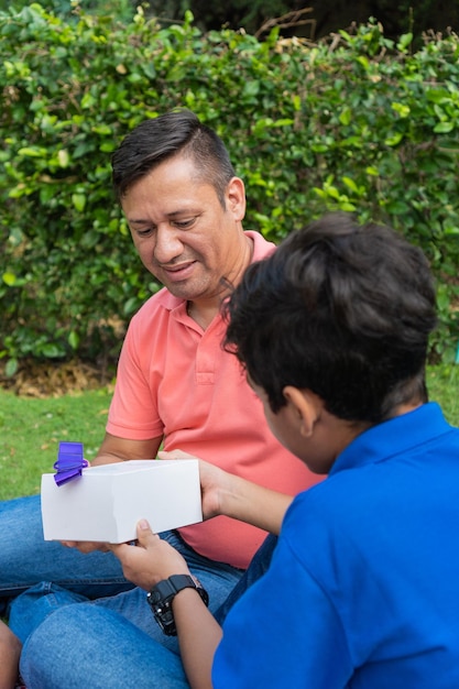 El hijo le da un regalo a los padres en el Día del Padre