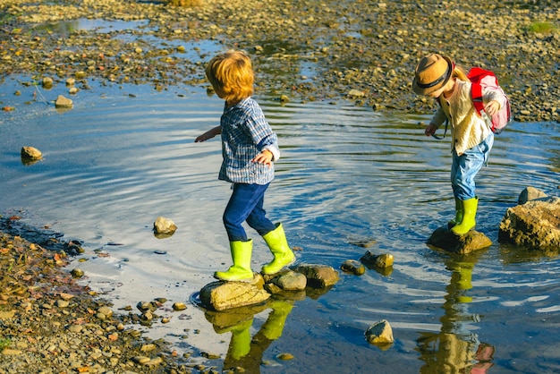 Hijo e hija jugando en el río Niños jugando en un arroyo de montaña Niños disfrutando de un hermoso día de verano