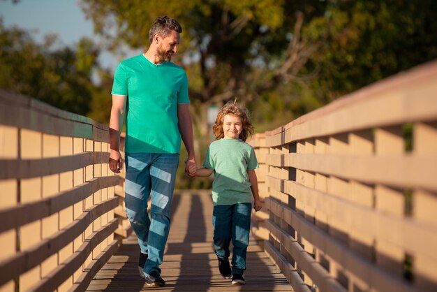 Hijo feliz estirando las manos padre Hombre guapo y chico lindo al aire libre