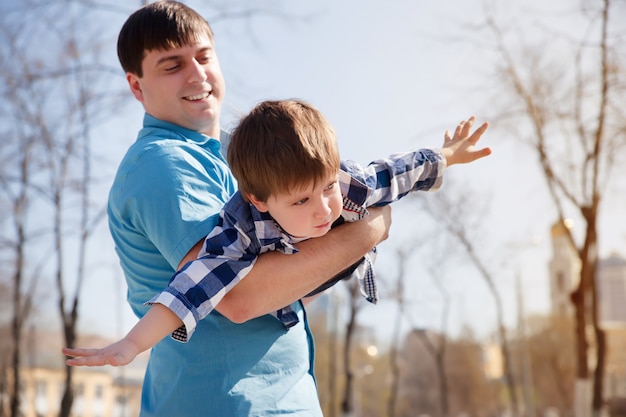 Hijo de padres en el parque divirtiéndose juntos