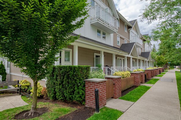 Hilera de casas adosadas con camino de hormigón delante en un día maravilloso en Vancouver BC