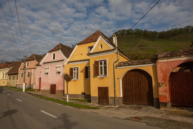 Una hilera de casas con una colina verde al fondo