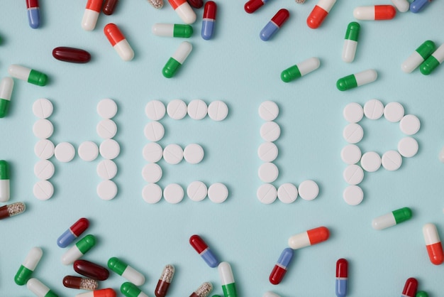 Hilfe-Schriftzug mit weißen runden Pillen pharmazeutische Medikamente orale Tabletten