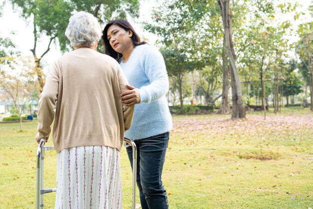 Foto hilfe und pflege asiatische senioren oder ältere alte dame frau verwenden wanderer mit starker gesundheit während des gehens im park in glücklichen frischen urlaub