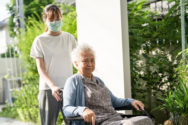 Hilfe und Pflege von Pflegekräften Asiatische Seniorin oder ältere Patientin einer alten Dame, die auf einem Rollstuhl sitzt, um im Pflegekrankenhaus ein gesundes, starkes medizinisches Konzept zu erreichen