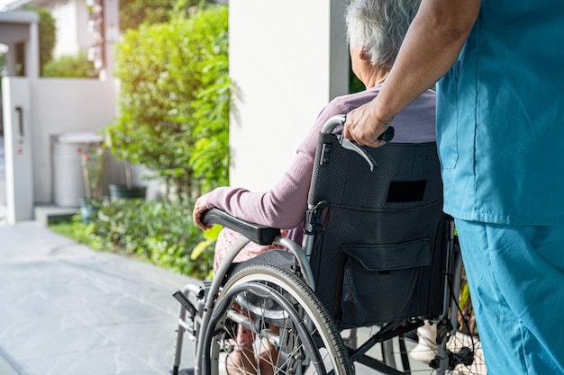 Hilfe und Pflege von Pflegekräften Asiatische Seniorin oder ältere Patientin einer alten Dame, die im Rollstuhl auf einer Rampe im Pflegekrankenhaus sitzt, gesundes, starkes medizinisches Konzept