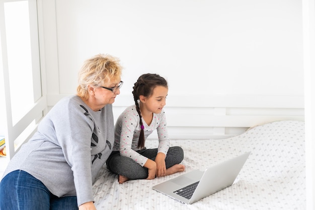 Hilfreiche Oma. Hilfreiche liebevolle Oma, die ihrer süßen Enkelin bei den Hausaufgaben hilft