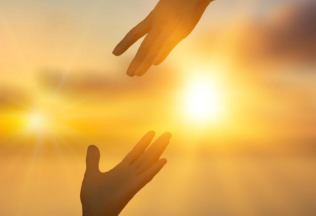 Hilfshand-Konzept Silhouette Hand auf Sonnenlicht-Hintergrund