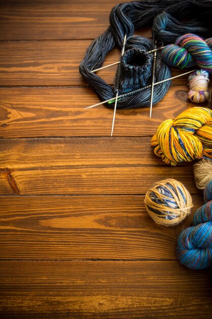Los hilos de colores, las agujas de tejer y otros artículos para tejer a mano