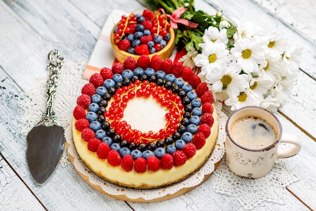 Himbeer-Heidelbeer-Käsekuchen auf Holztisch