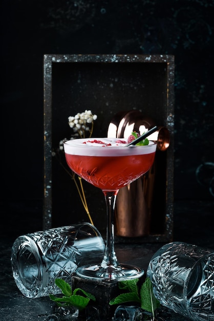 Himbeer-margarita-cocktail mit himbeerlikör in einem glas bar-menü auf schwarzem hintergrund