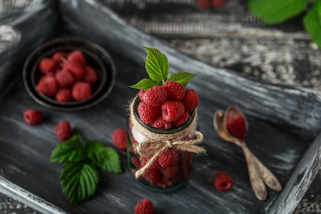 Himbeere in einem Glas auf dunklem Holztisch. Gesundes Lebensmittelkonzept. Frische Bio-Beeren